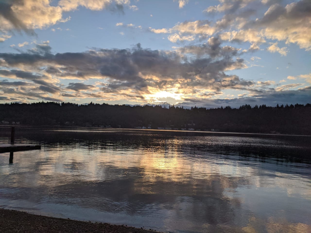 A wooden dock on a lake at sunset