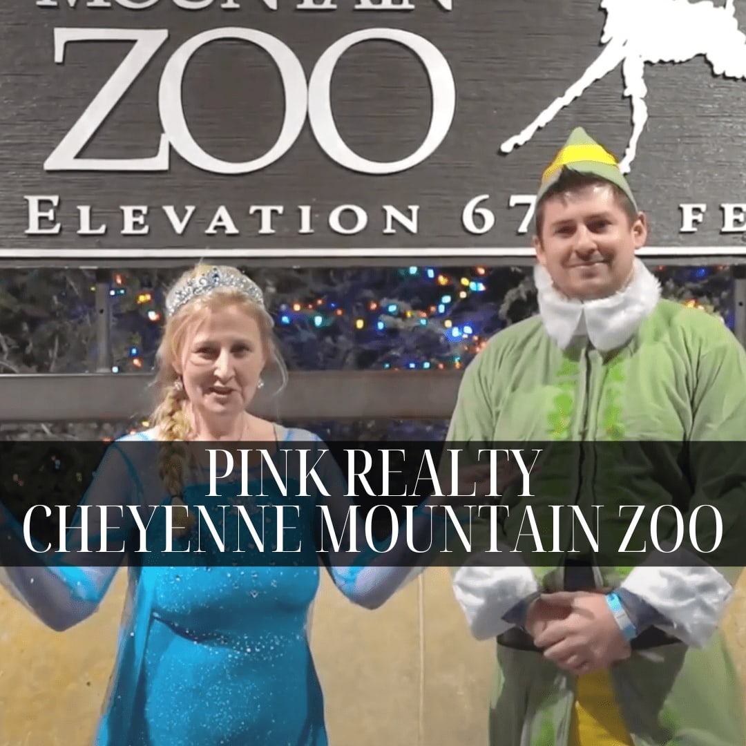 Two people dressed in costumes with text overlay that reads 'PINK REALTY CHEYENNE MOUNTAIN ZOO'.