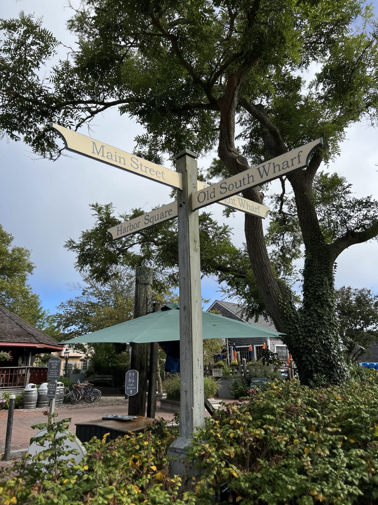 Wood street sign in Nantucket pointing to Main Street, Harbor Square, and Old South Wharf.