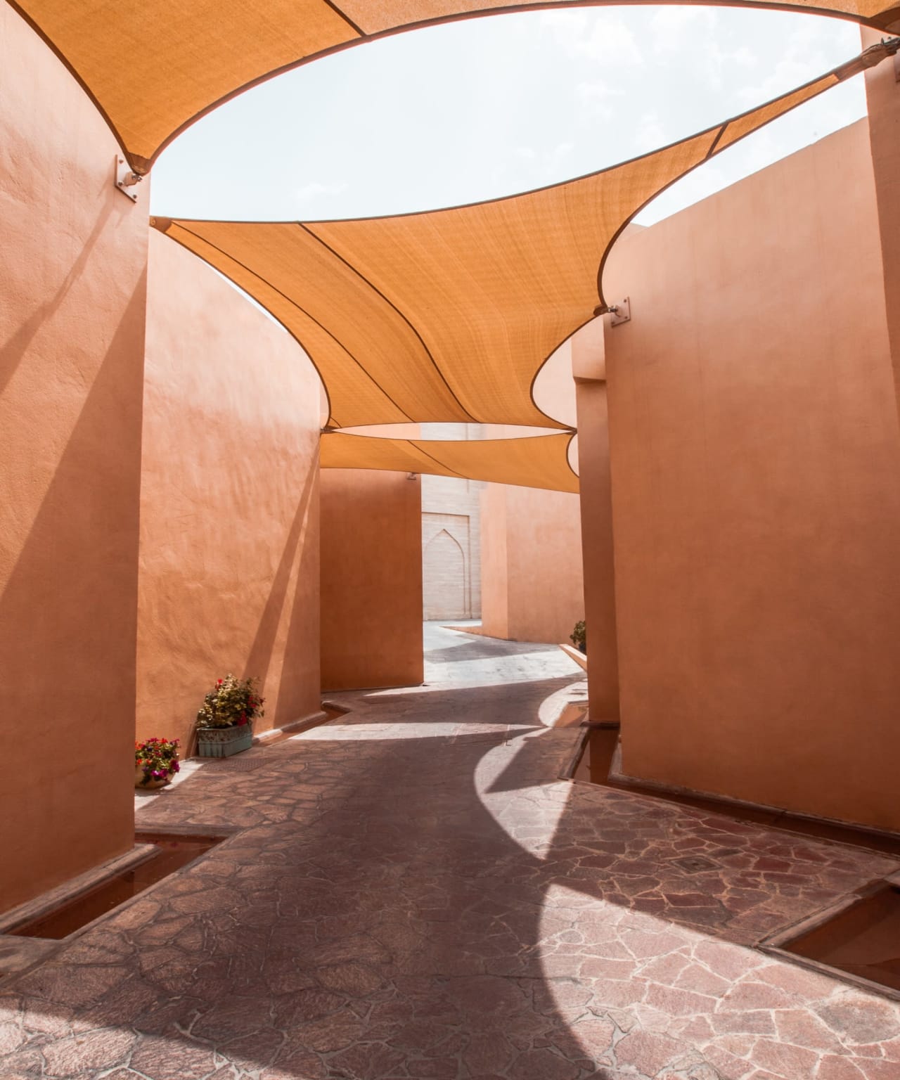 A shaded walkway between two buildings made of brick.