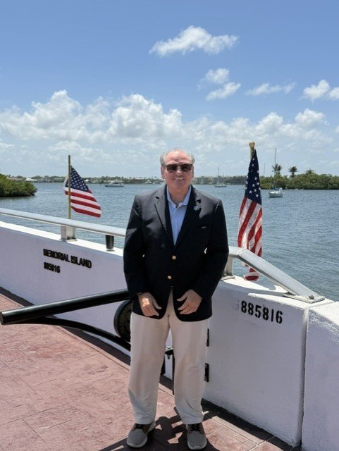 Ben Bryk on Memorial Island in Vero Beach, framed by American flags over the Indian River Lagoon.