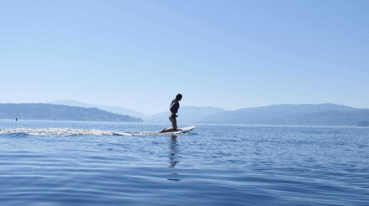 a woman kneeling in her surfboard in a calm sea water