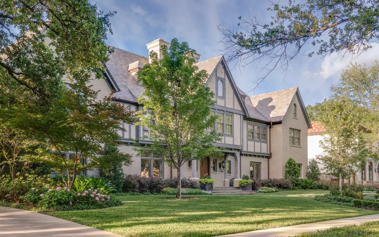 A large house with a lush green lawn in front of it.