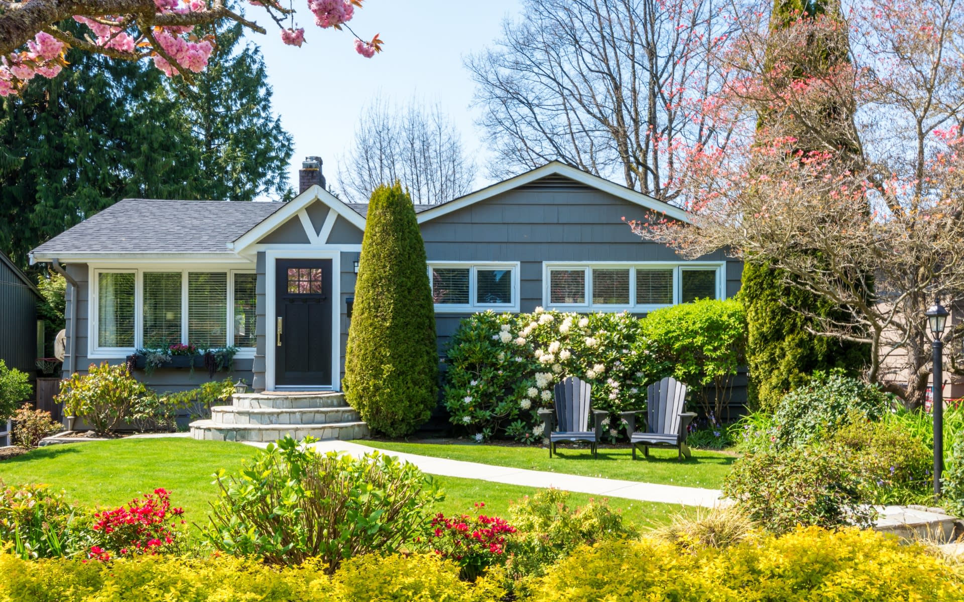 a house with a well-maintained lawn and flower garden.