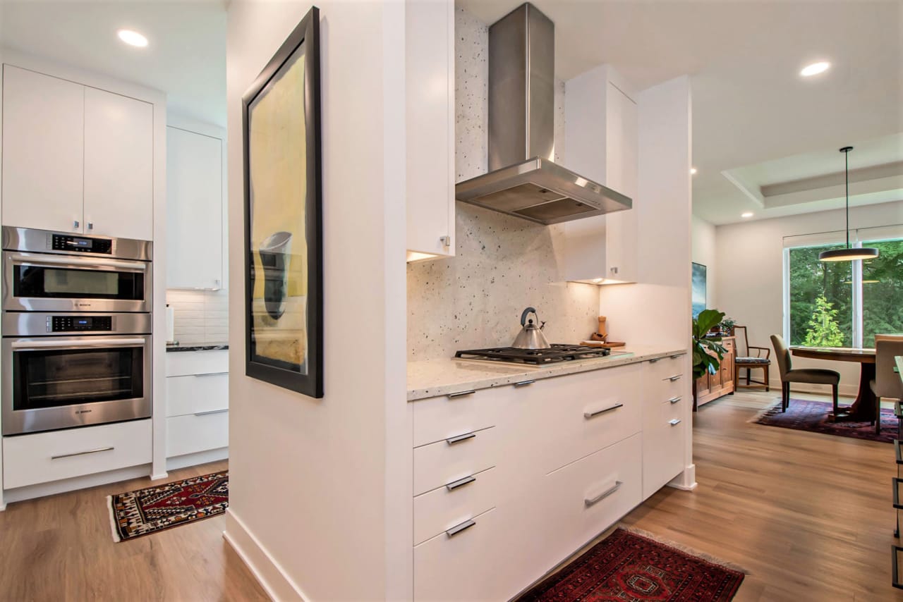 A kitchen with white cabinets and stainless steel appliances