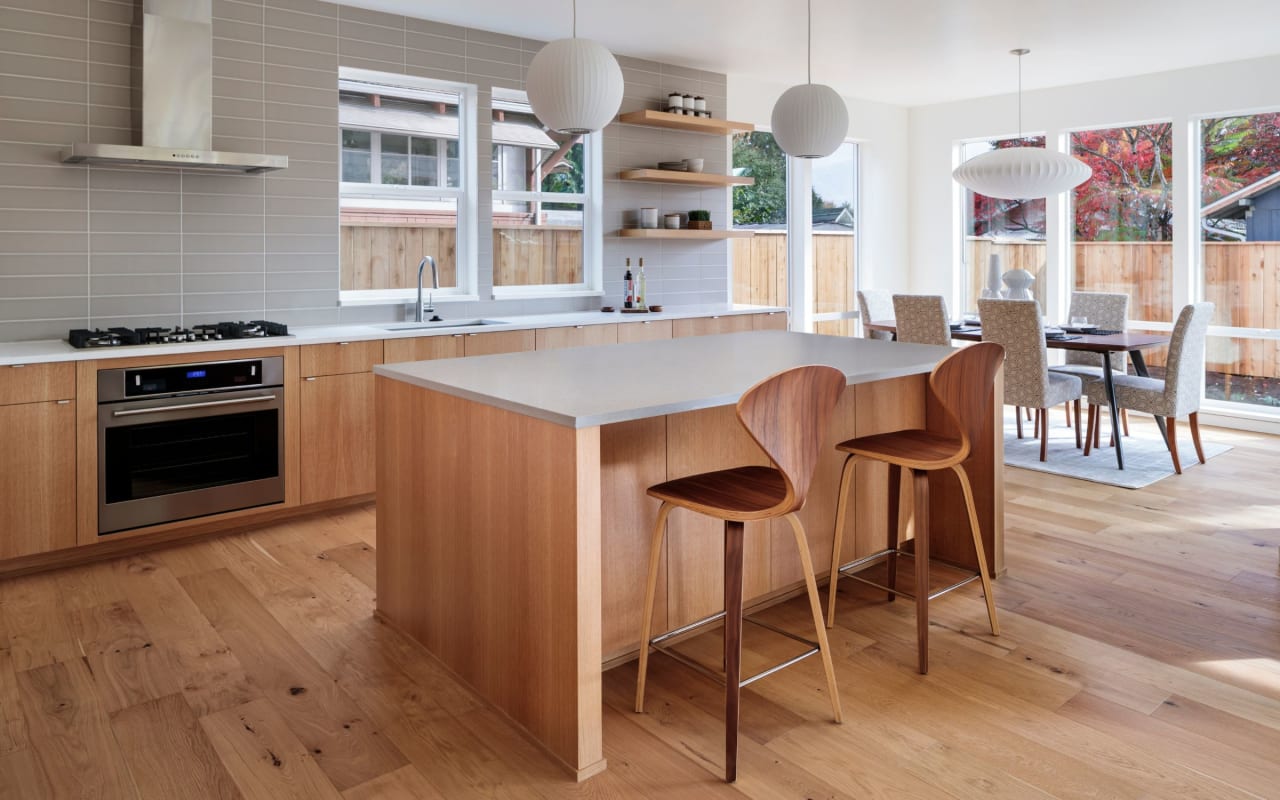 A modern kitchen with a large island and two bar stools