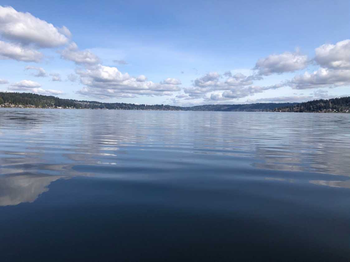 A large, deep blue lake with green mountains in the background