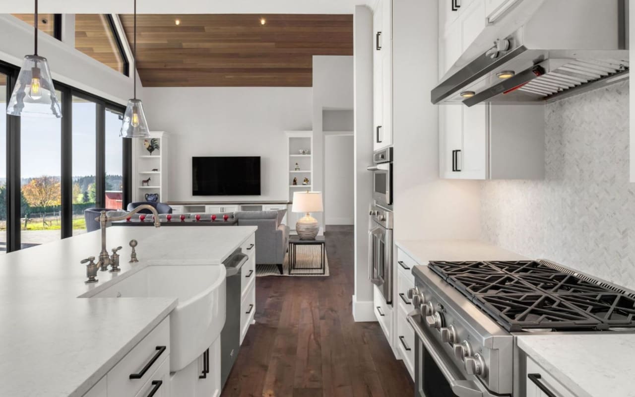 A stainless steel sink and faucet on the left and a black stove with four burners on the right.