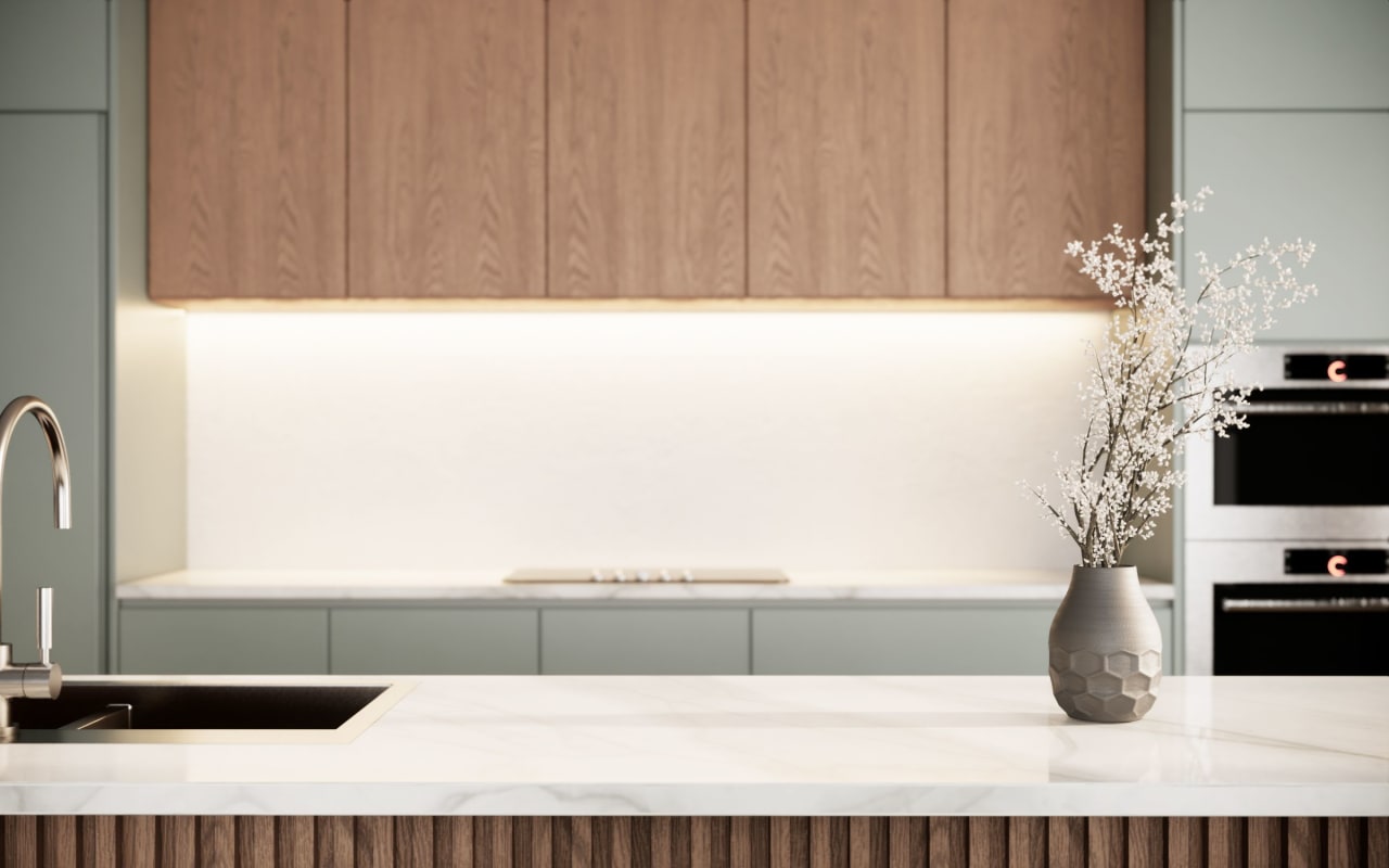 A modern kitchen counter with a vase of colorful flowers on it.