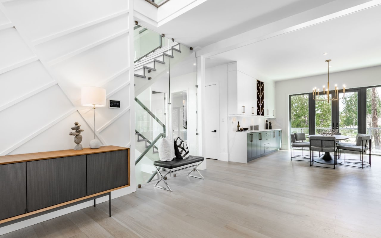 A modern, open-concept living space with white walls and hardwood floors