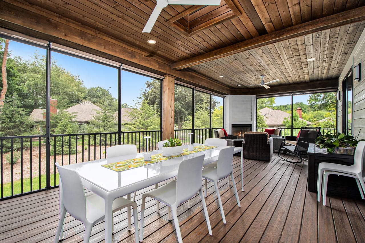 A screened-in porch with a table and chairs