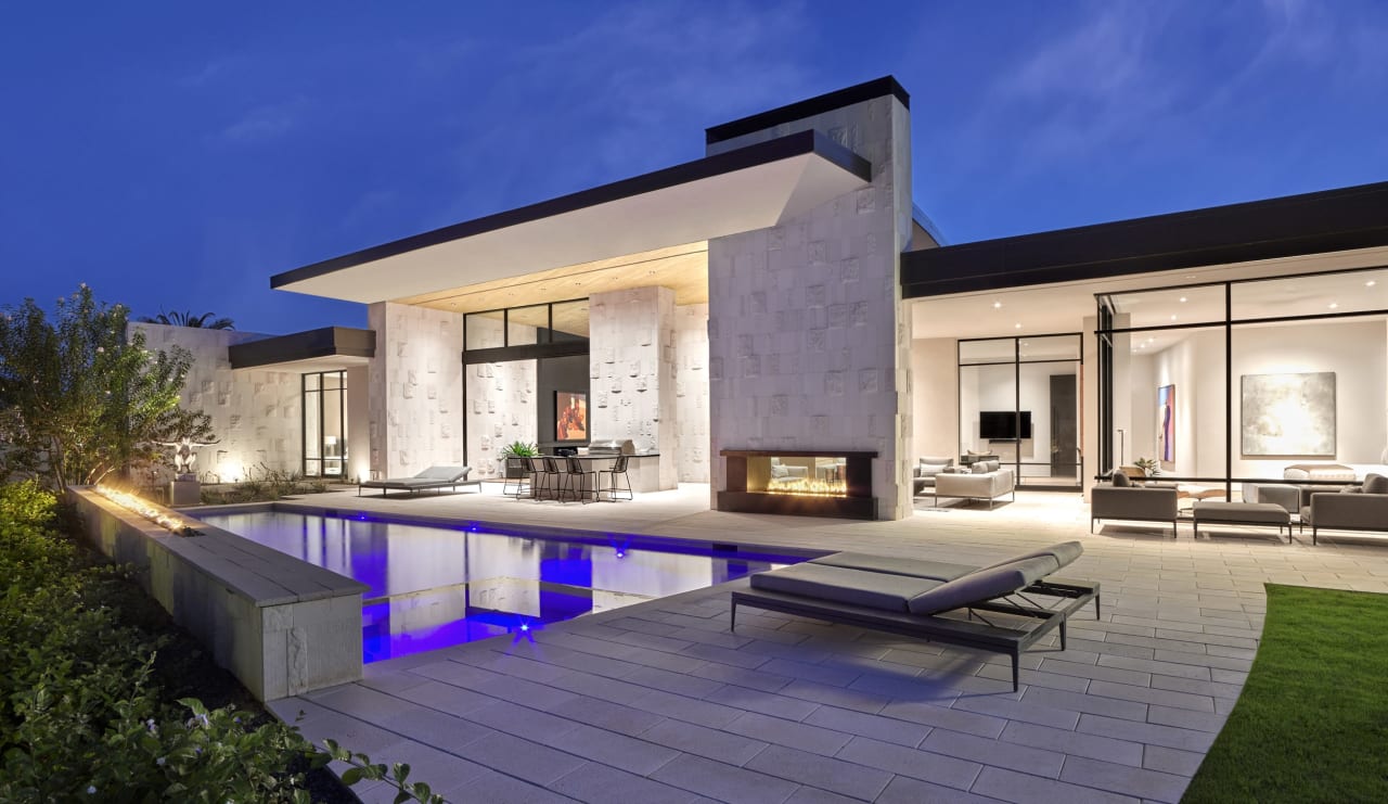 Bakcyard of luxury modern home with white limestone and pool