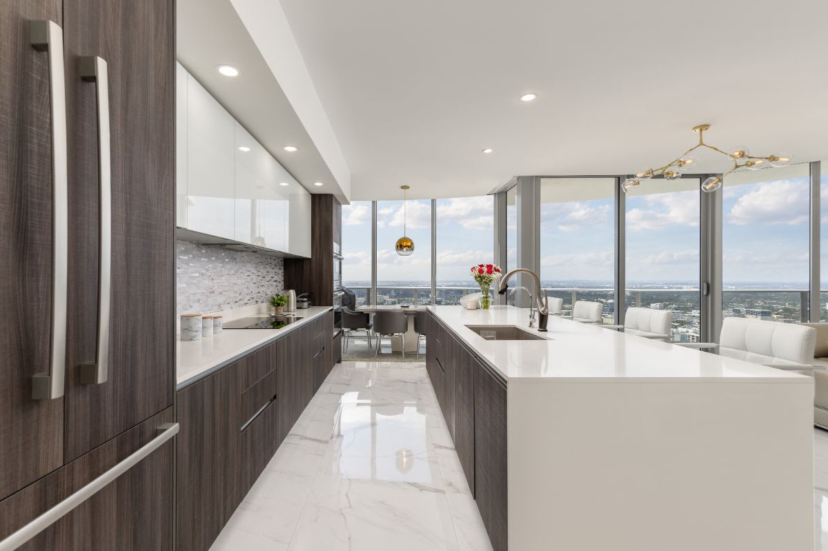 A kitchen with a large island, a refrigerator, and a sink