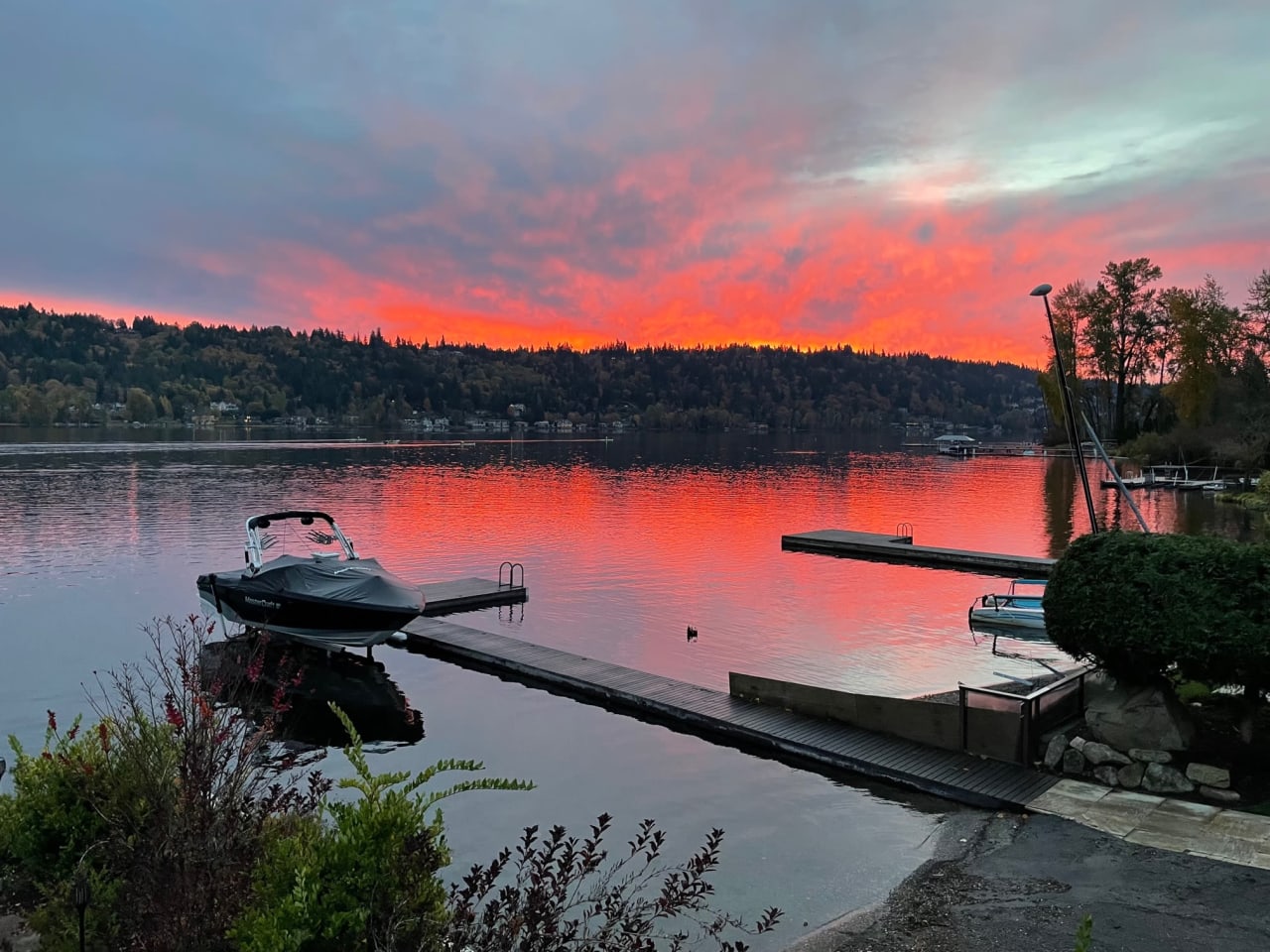 A boat docked at a dock on a lake at sunset