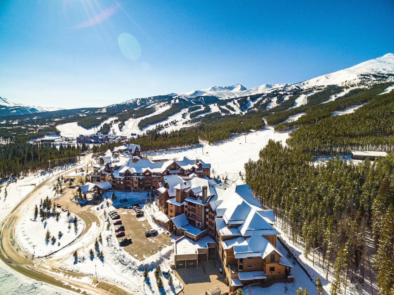 An aerial view of a ski resort nestled in a snowy mountain valley