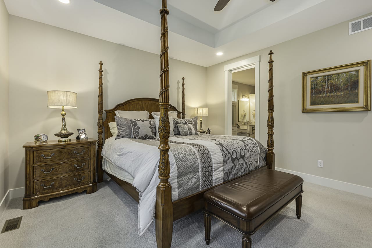  A bedroom with a wooden four-poster bed and a wooden bench