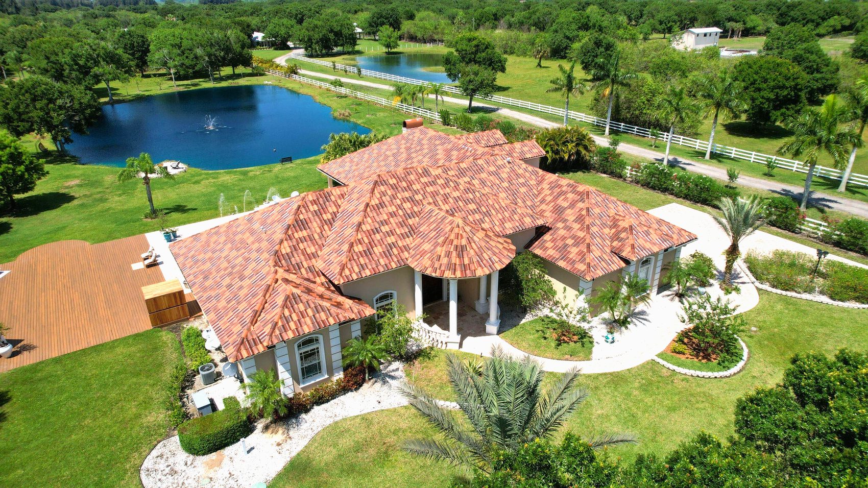 Aerial view of a private 4.61-acre Vero Beach estate with a stocked lake and pool, illustrating the privacy and mature landscaping buyers look for