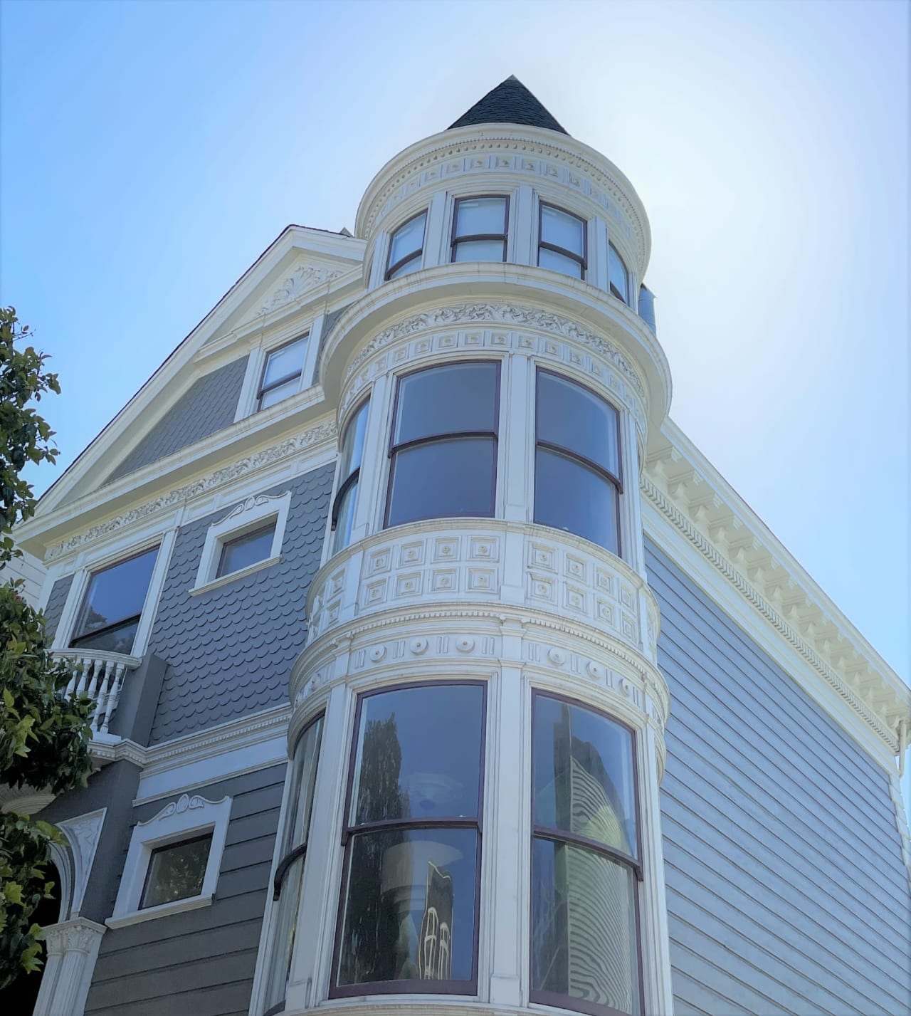 A tall house with a very tall tower and many windows. The tower is made of glass and metal.