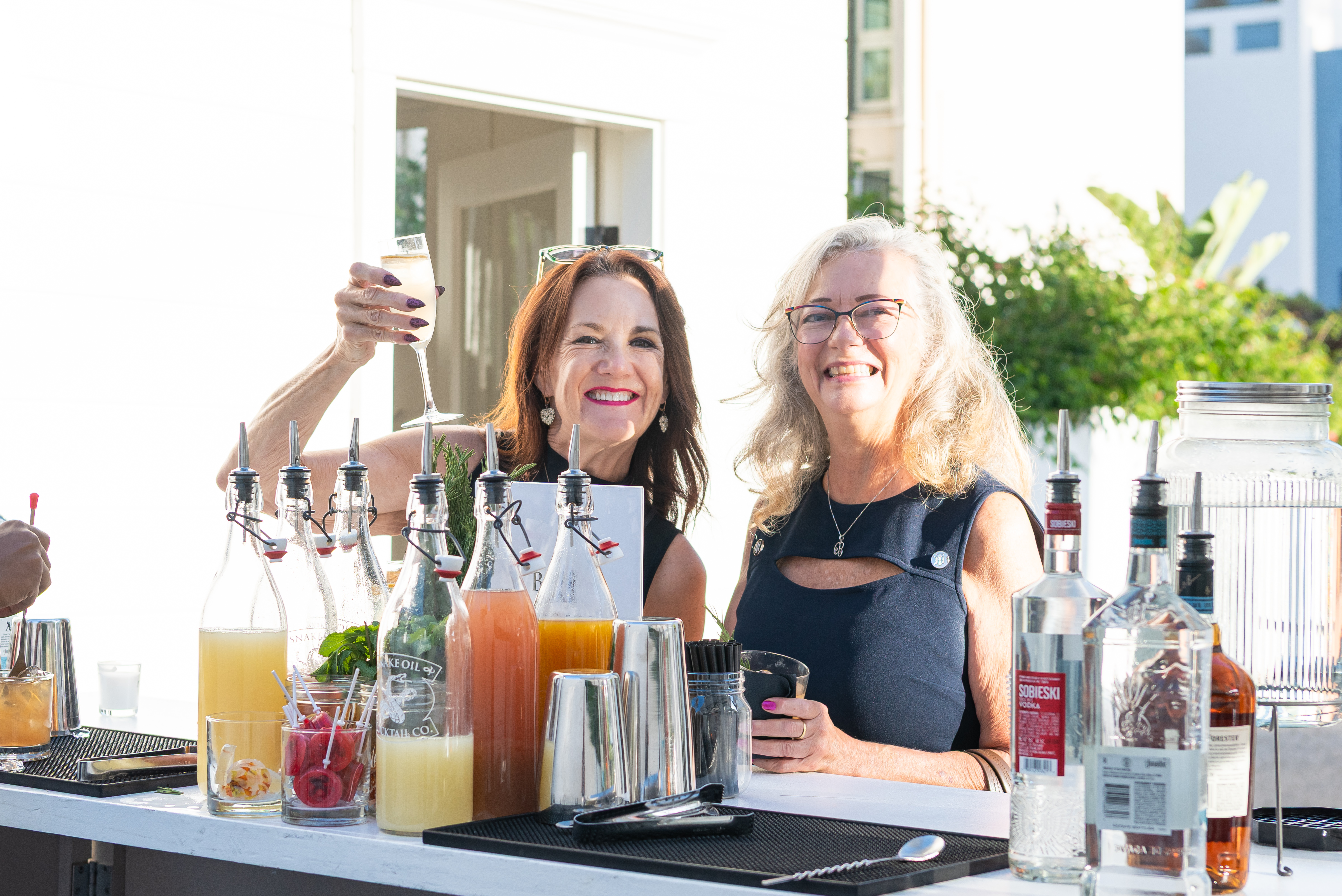 Two guests raising glasses at the outdoor bar
