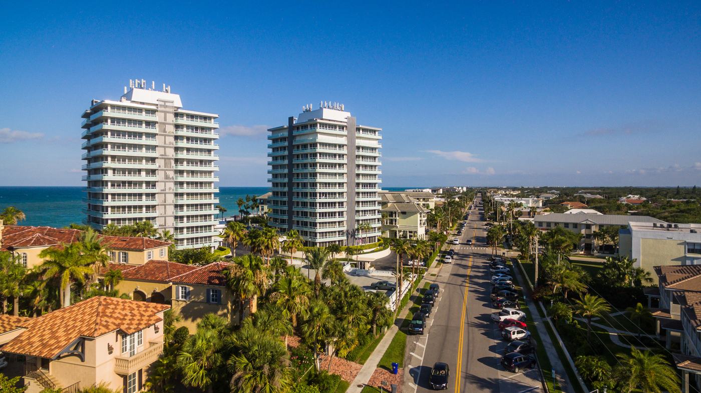 Two oceanfront condominium towers rise above Ocean Drive on the Vero Beach barrier island, viewed from the air looking south