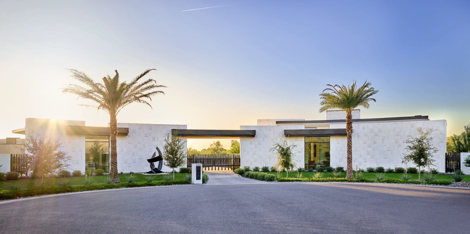 Radius shaped home with white stone and black accents