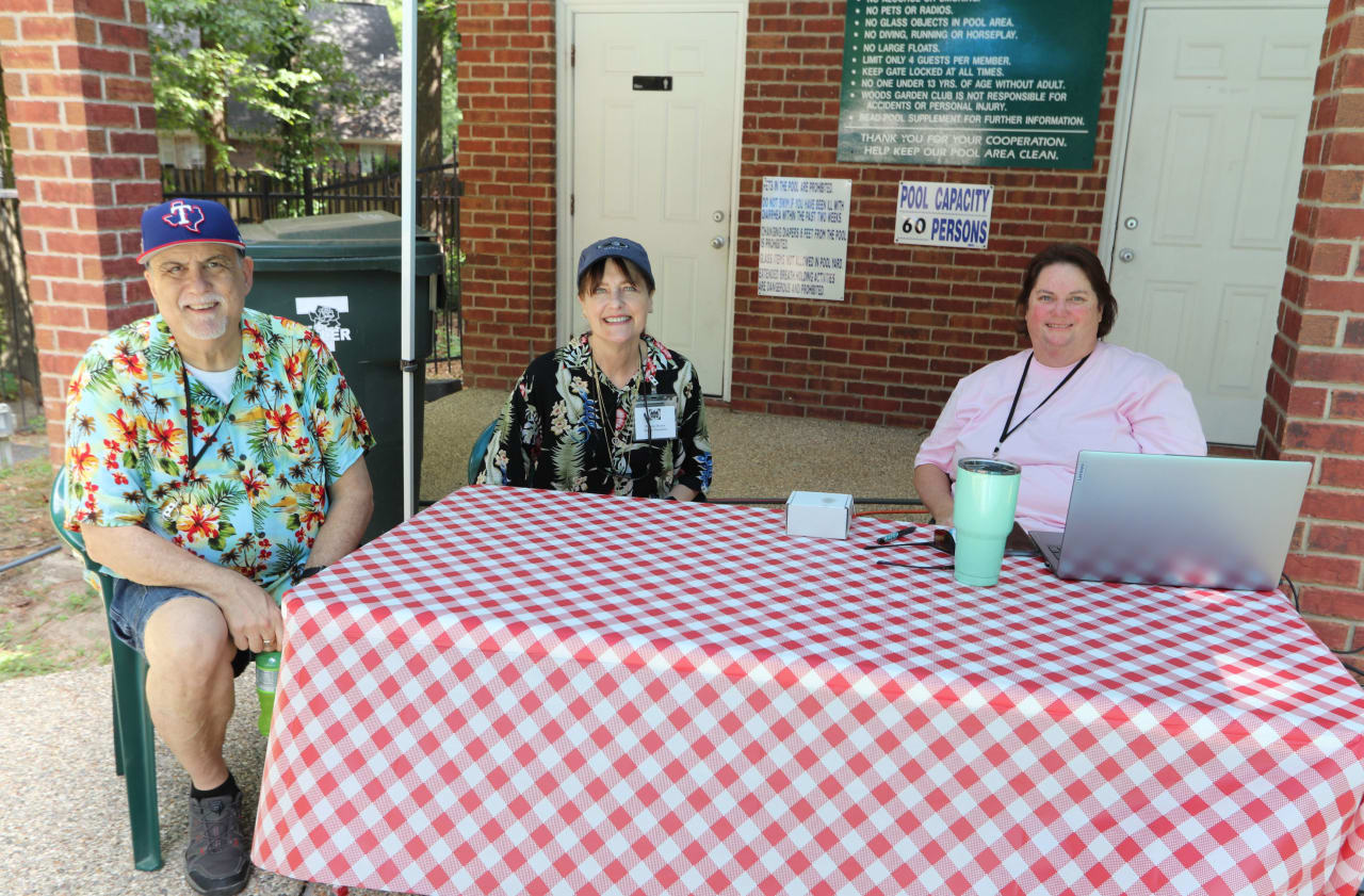 three people sitting with checkered table cloth