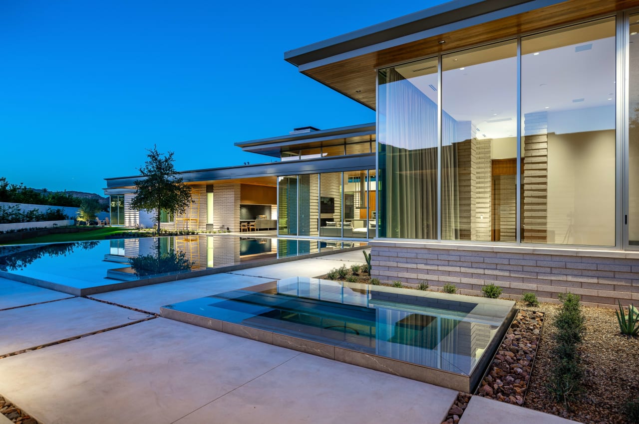 Floating pool in backyard of modern home at dusk