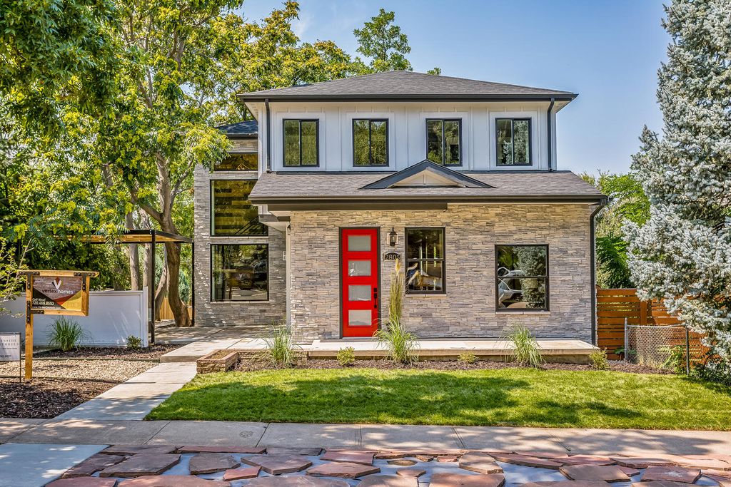 A modern two-story house with a striking design, featuring a combination of light gray stone cladding on the lower level and white horizontal siding on the upper level.