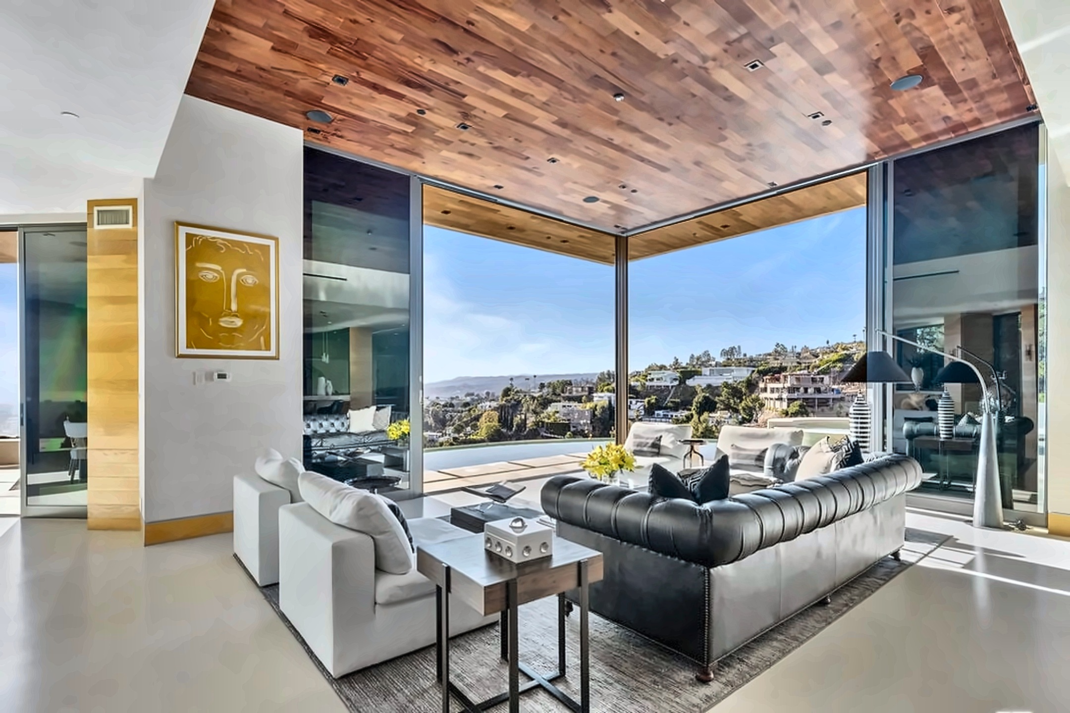 Living room with floor-to-ceiling glass opening to Hollywood Hills and city views