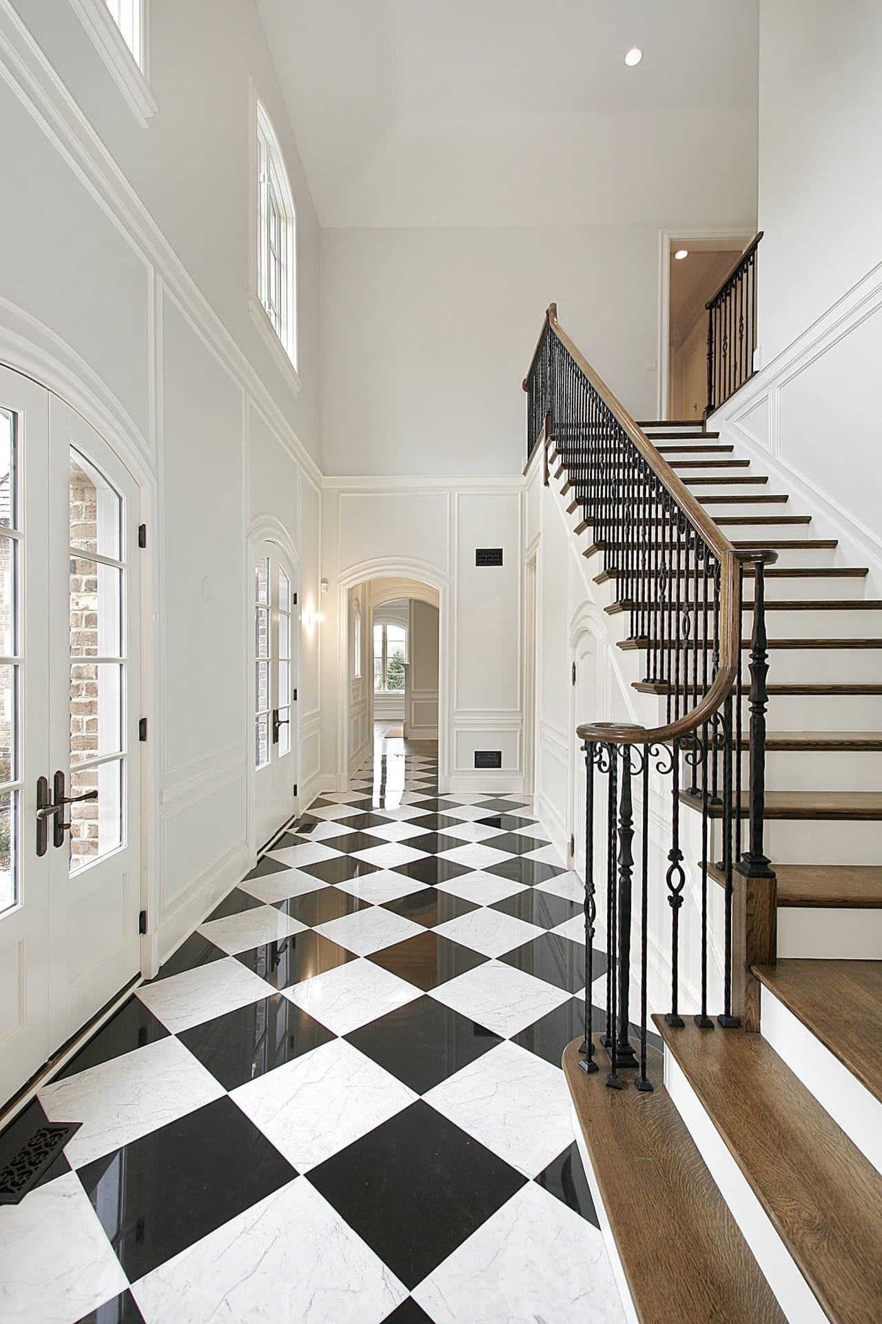 white hallway interior and stairs with black and white checkered floor