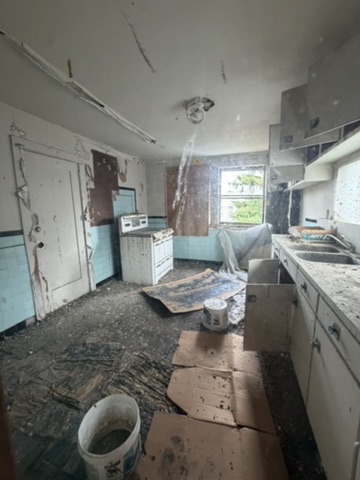 Kitchen at 964-966 York Street with a collapsed ceiling from a long-running roof leak, Mission District San Francisco