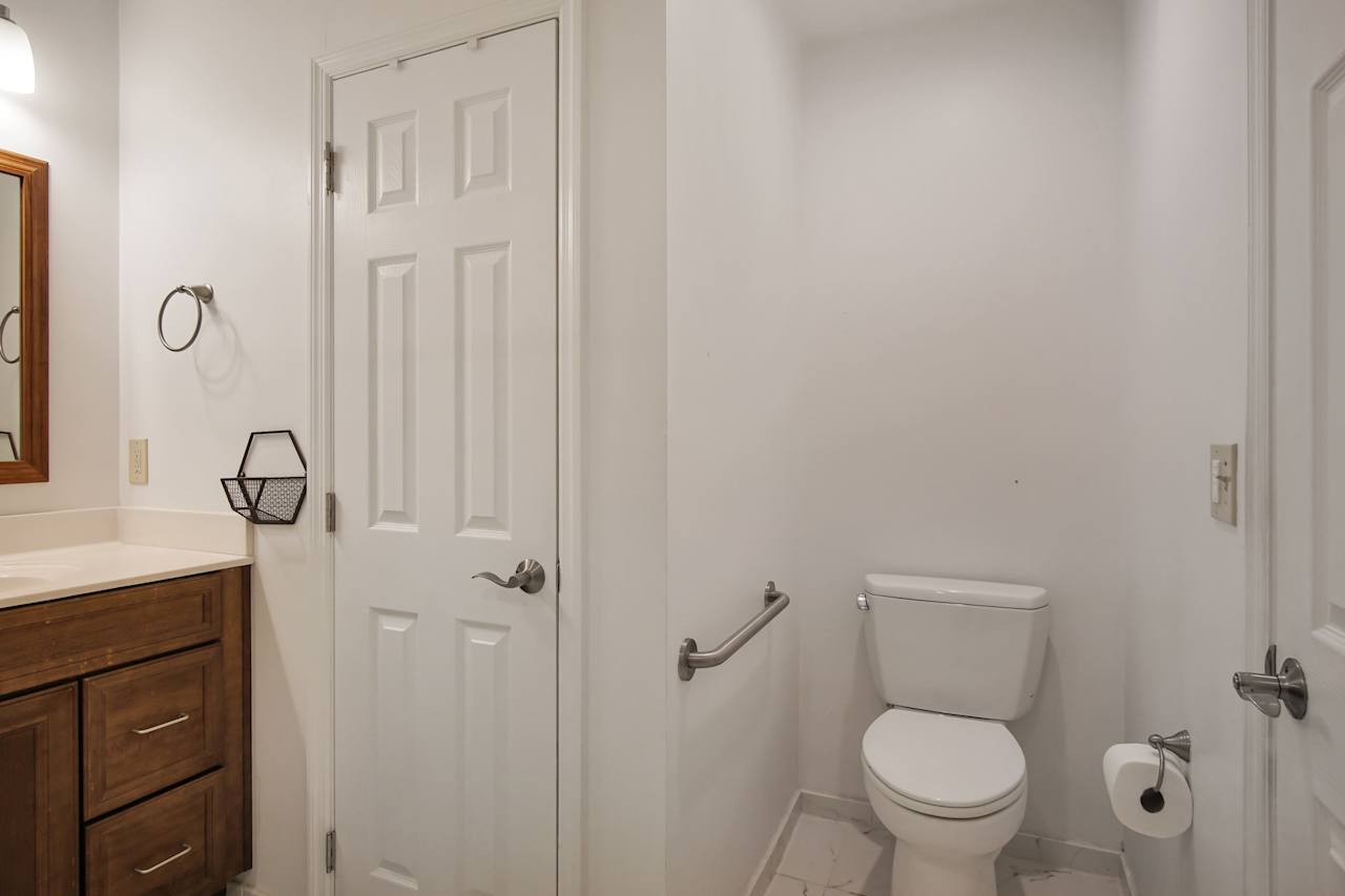 Photo of the guest bathroom featuring a large towel closet, and a separate toilet area with assistance rail at 1228 Winifred Drive, Tallahassee, Florida 32308