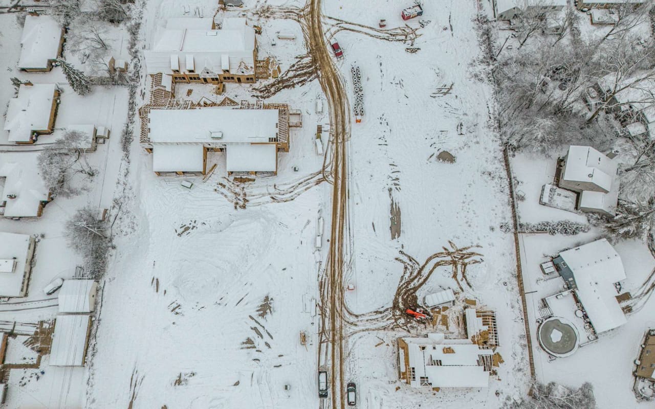 a close-up aerial view of homes covered in snow