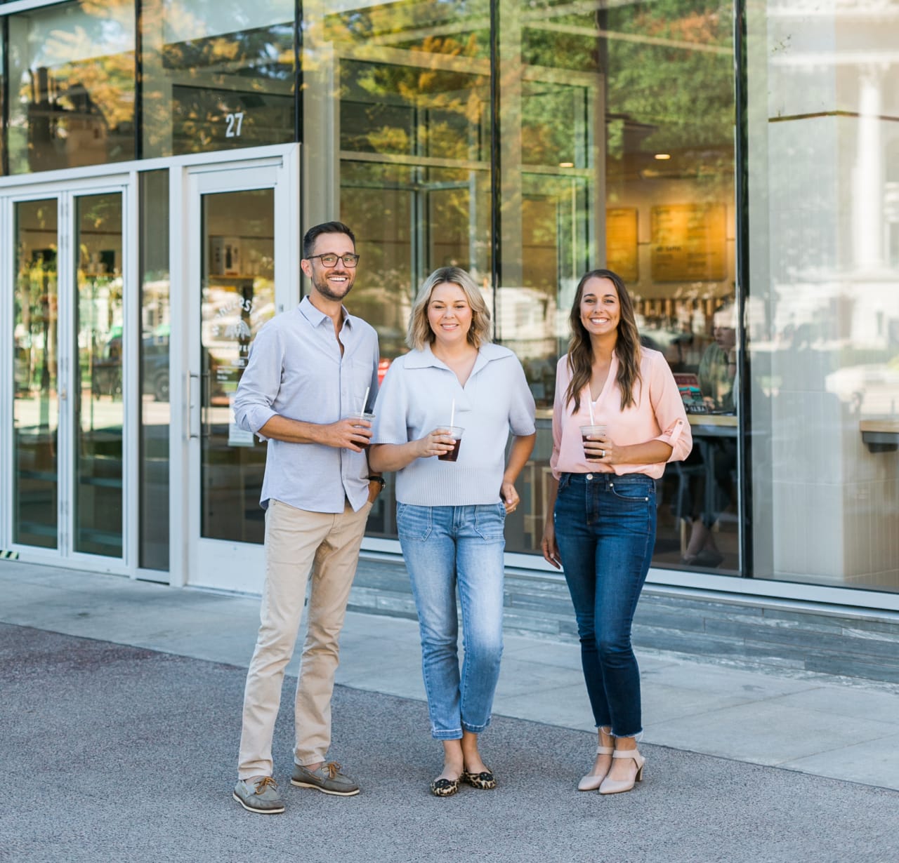 The Insiders Realty team, consisting of three real estate professionals, standing outside a building.