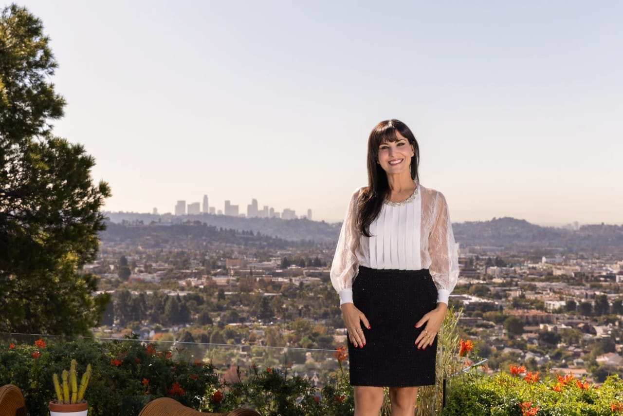 Silva Hameline, a real estate expert at Hameline Global, poses with a city skyline in the background.