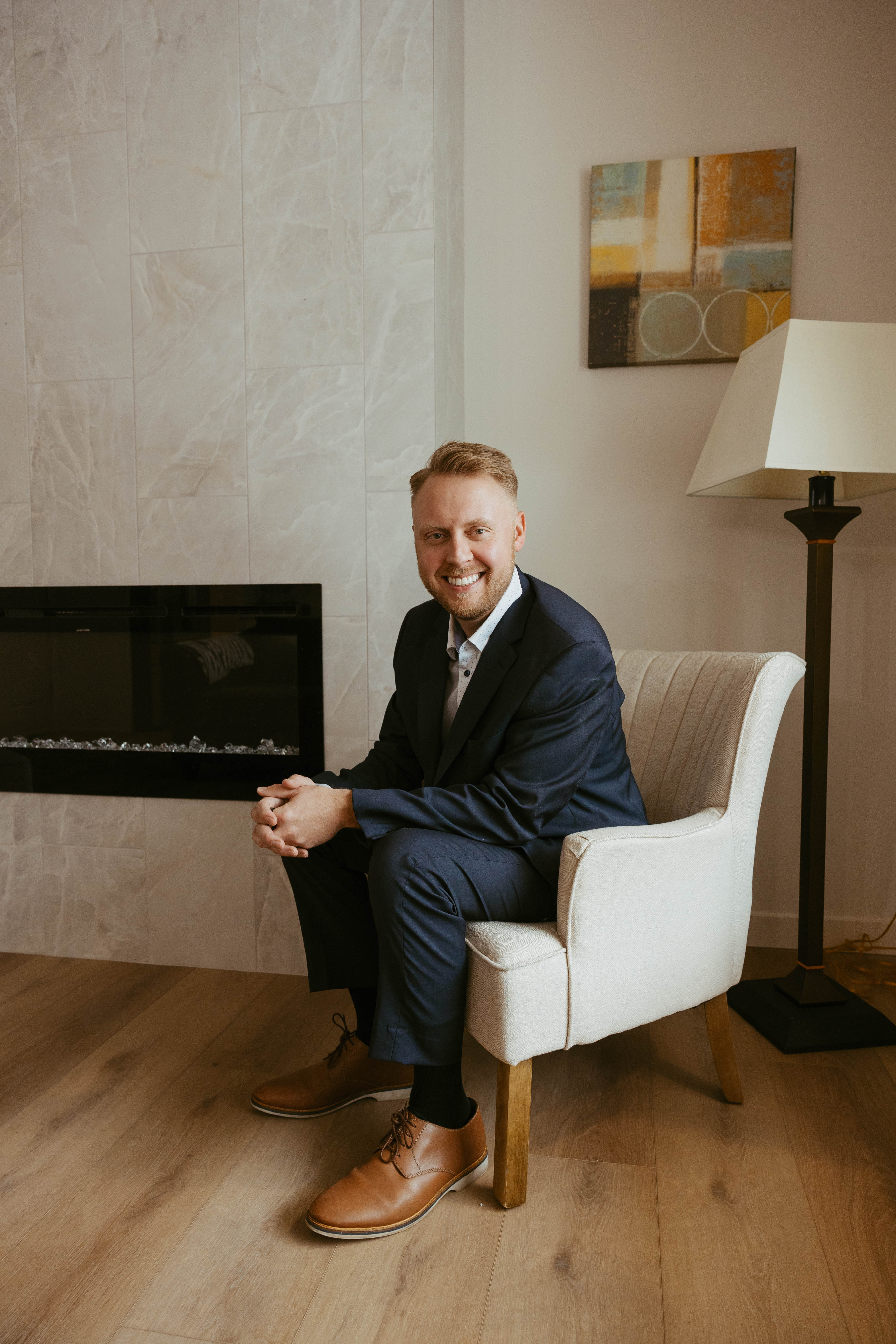 Jordan Vorderbrueggen seated beside a fireplace