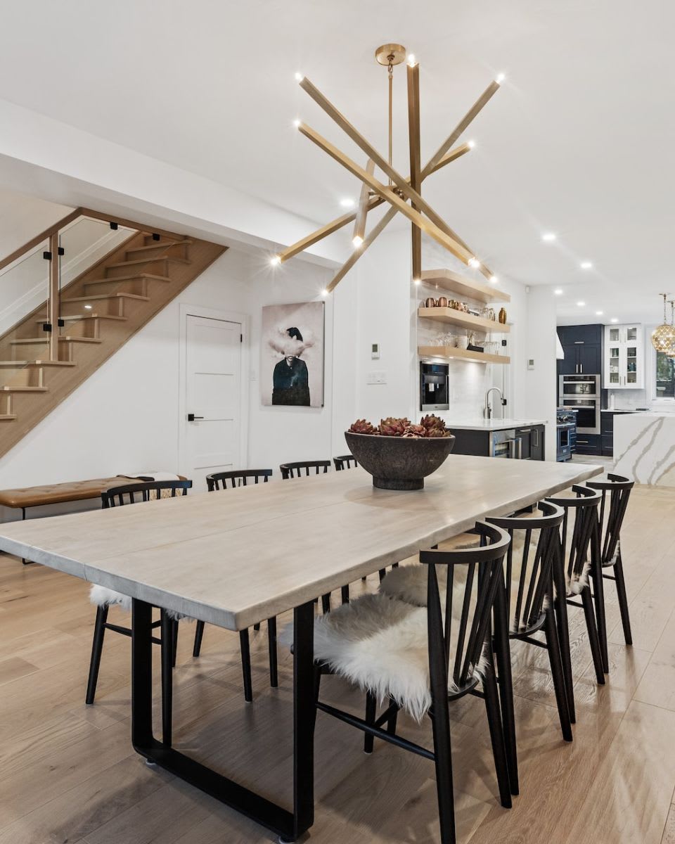 A dining room with a long wooden table and chairs with fur seating.