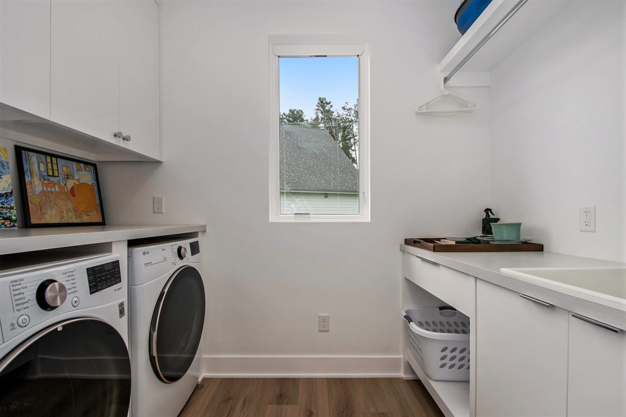 laundry room with two washing machine with window in the center