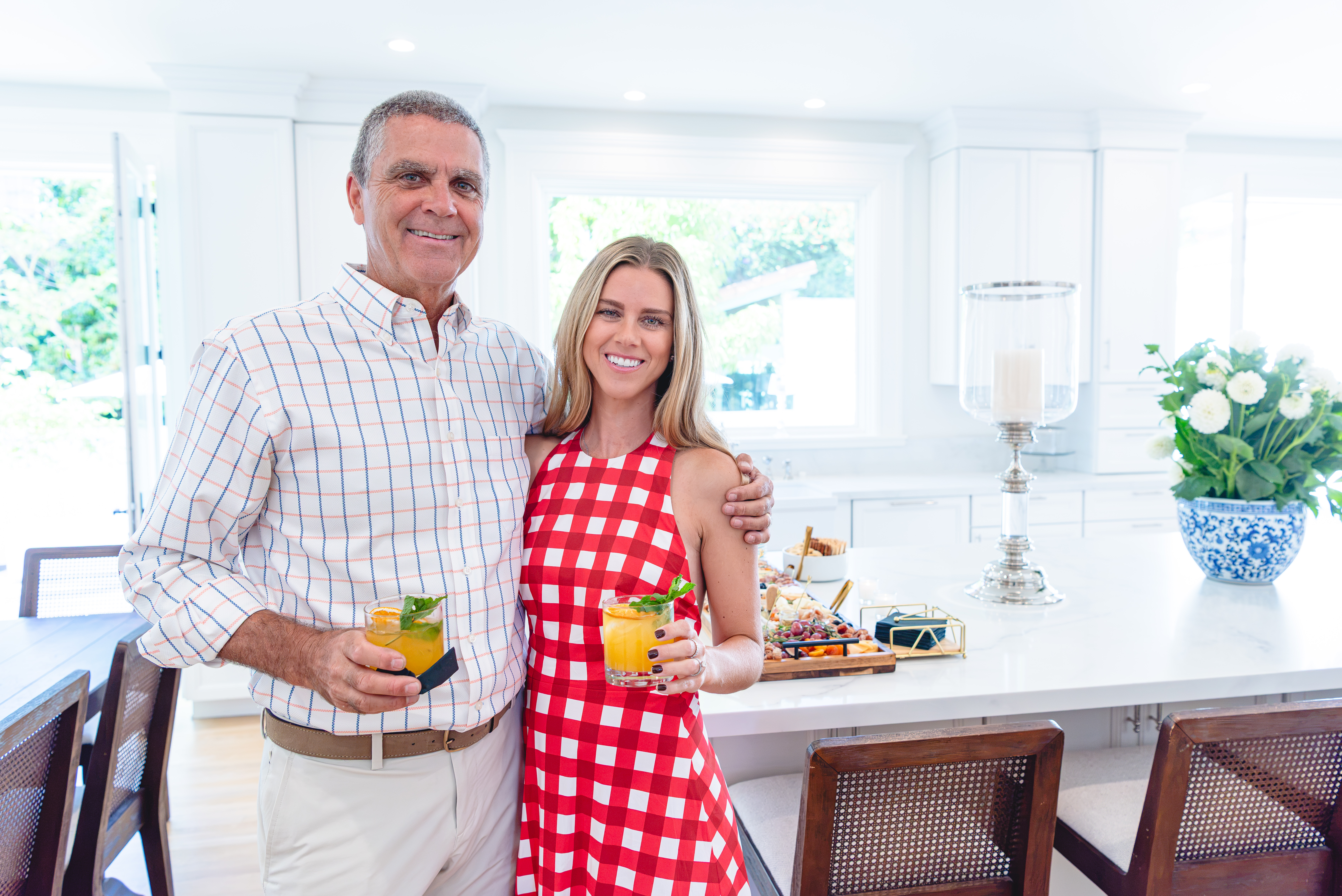 Two guests holding cocktails at the kitchen island