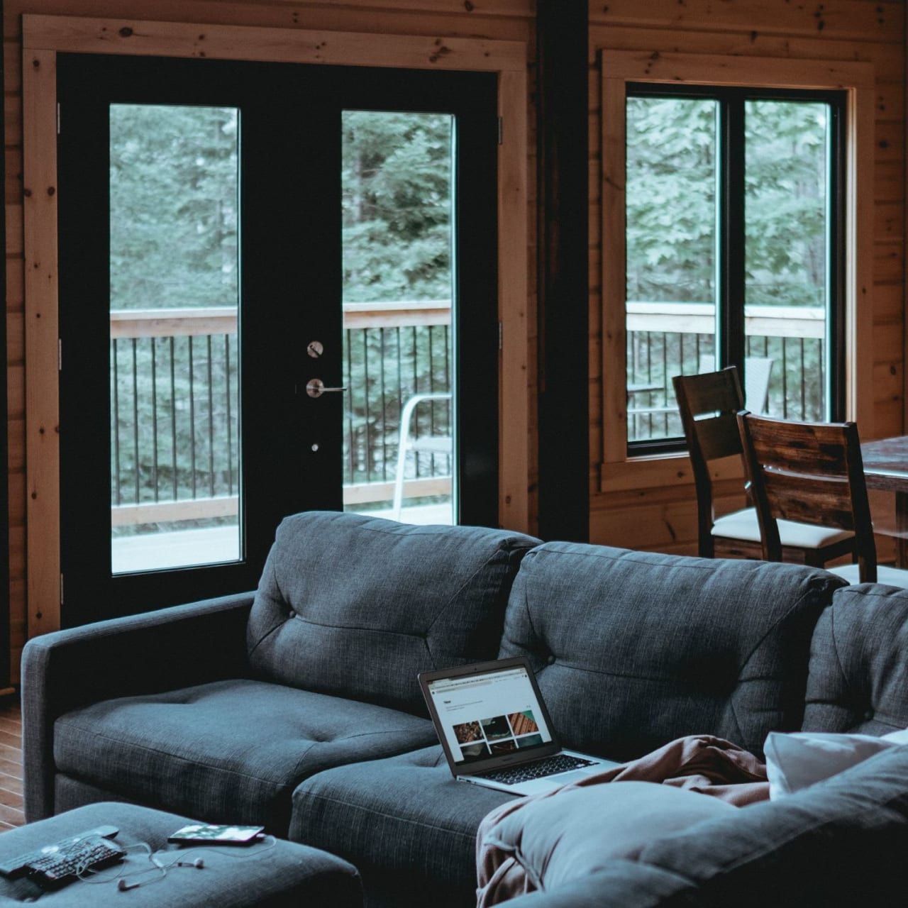 A laptop sits on a couch in a living room.