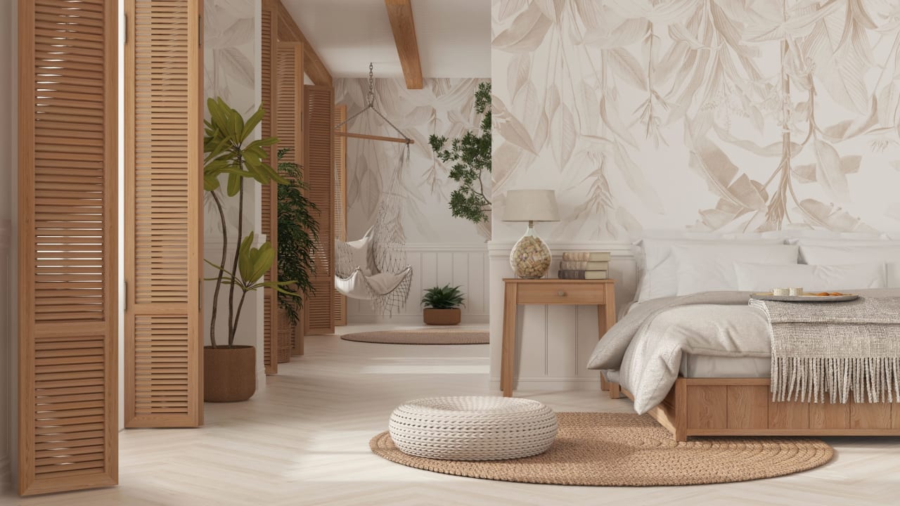 A bedroom with a wooden bed frame, a white comforter, and a patterned rug.