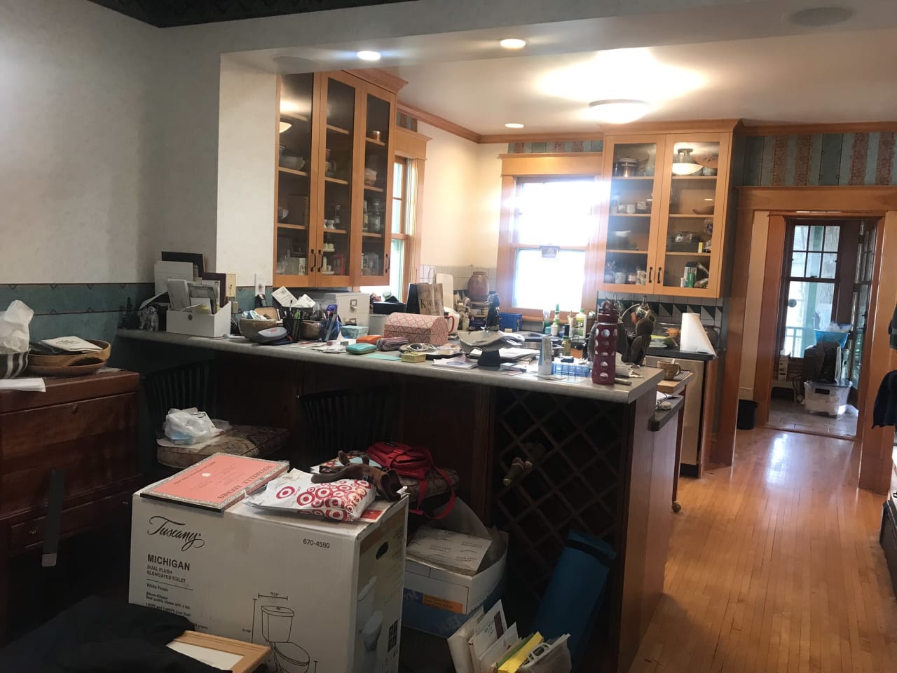 A cluttered kitchen counter with dishes, appliances, and a box.