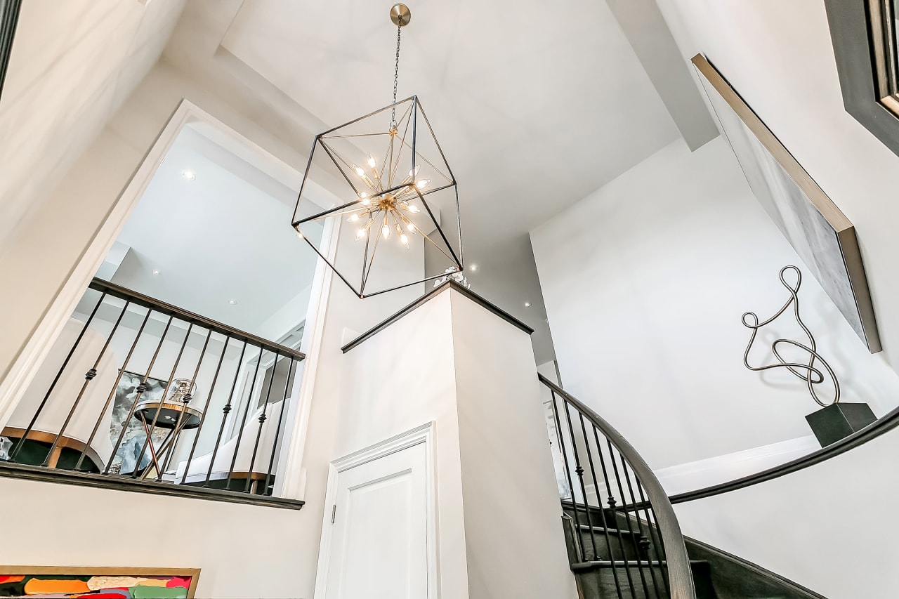 A view of a staircase with a chandelier hanging from the ceiling.