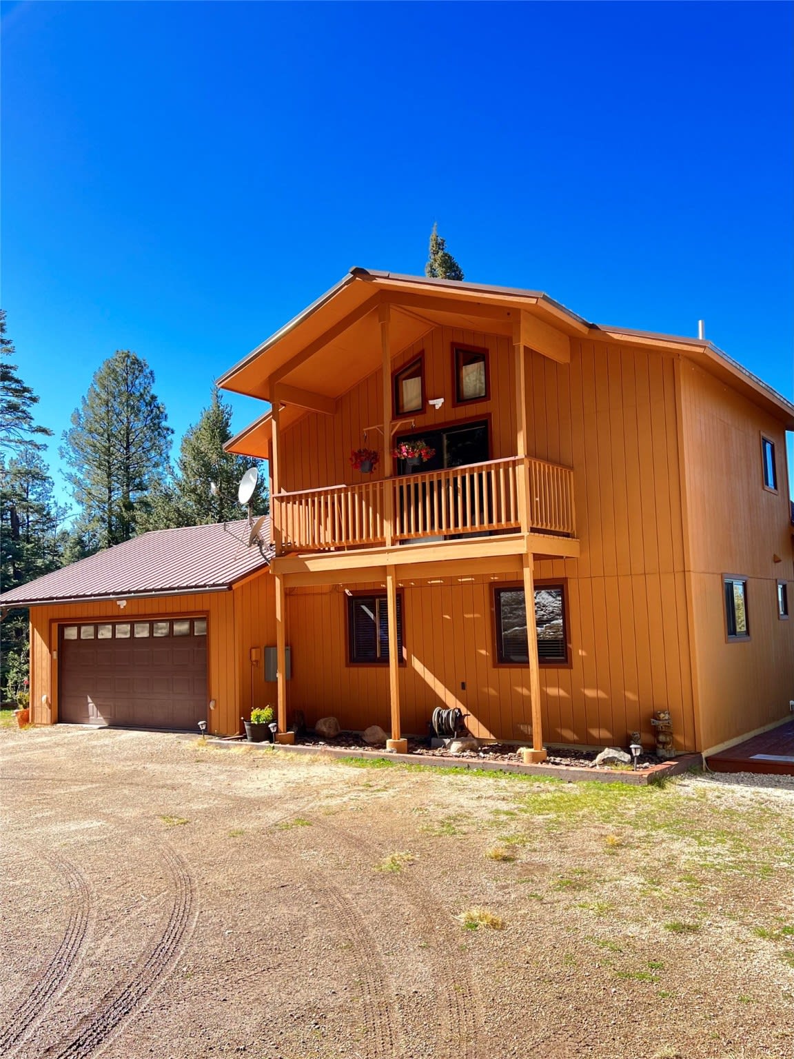 A large wooden house with a garage and a balcony.