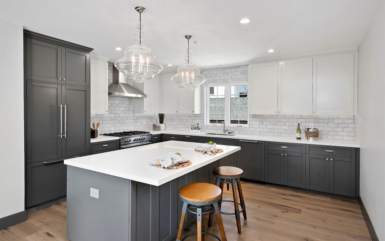 open kitchen with white and grey cabinetry and white tile backsplash