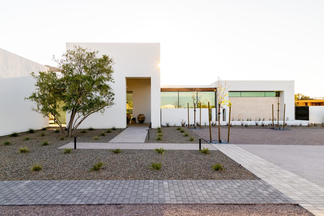 Entry and motor court of all white modern home