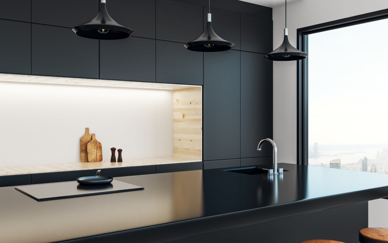 Modern black kitchen with minimalistic design, featuring pendant lighting, a sleek countertop, and a large window.