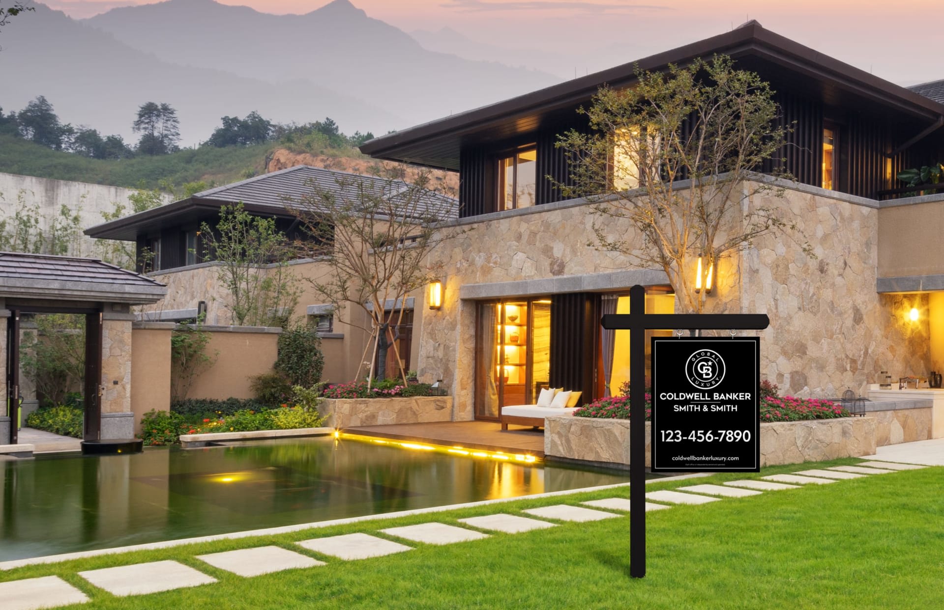 A Coldwell Banker sign in front of a large house with a foggy sky in the background.