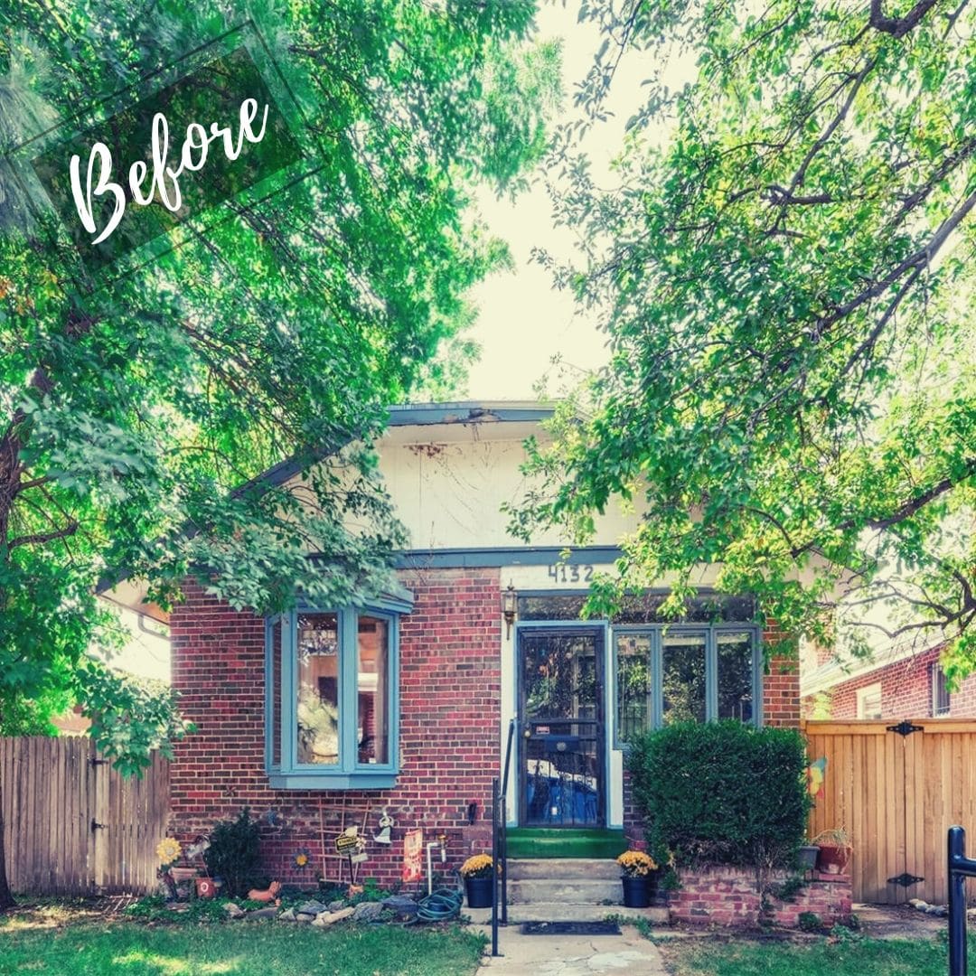 The house has a blue-trimmed bay window on the left and a dark blue front door with a screen door in the center, flanked by other windows