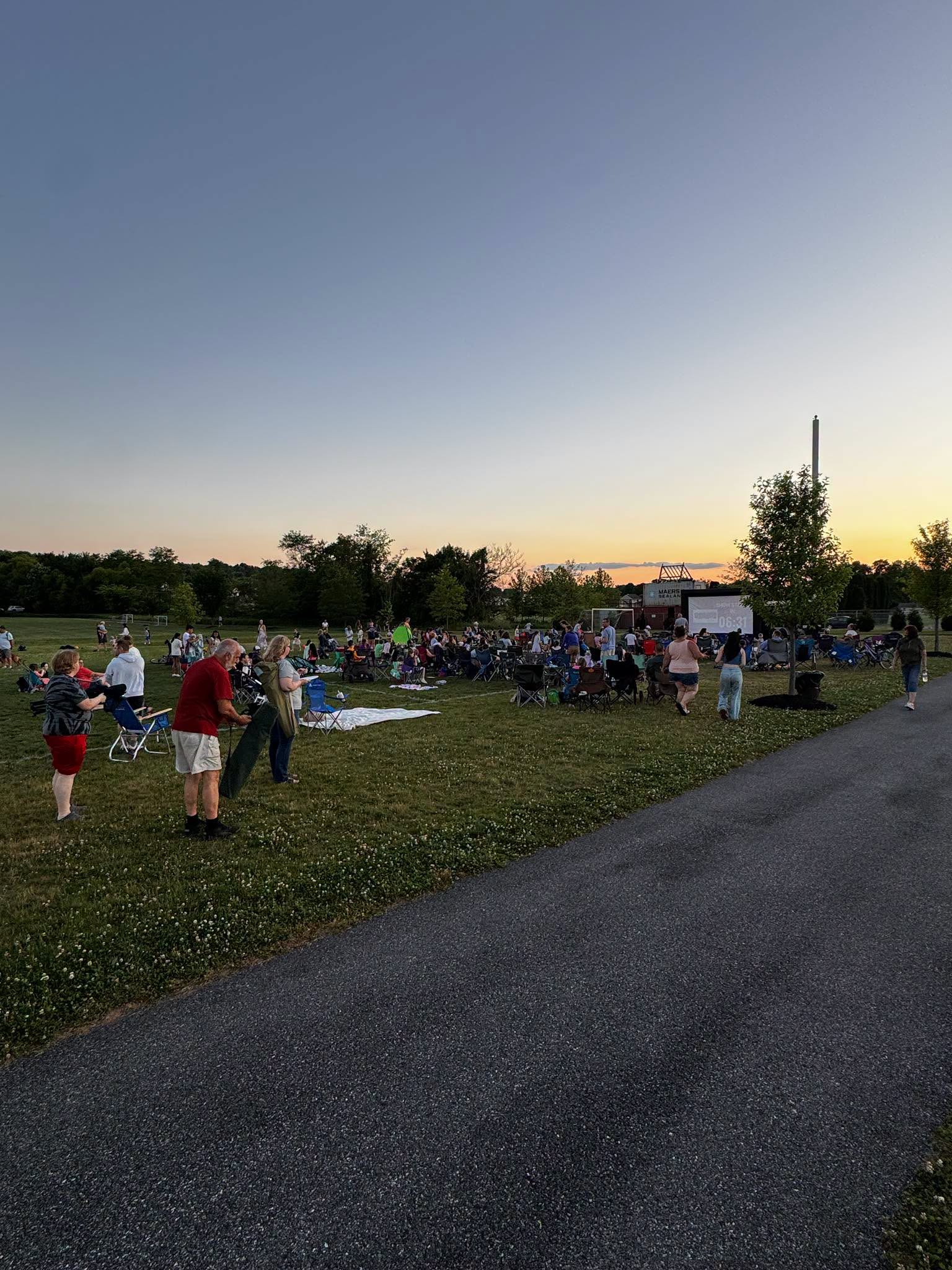 Families gathering at sunset for outdoor movie night at Campbelltown Community Park
